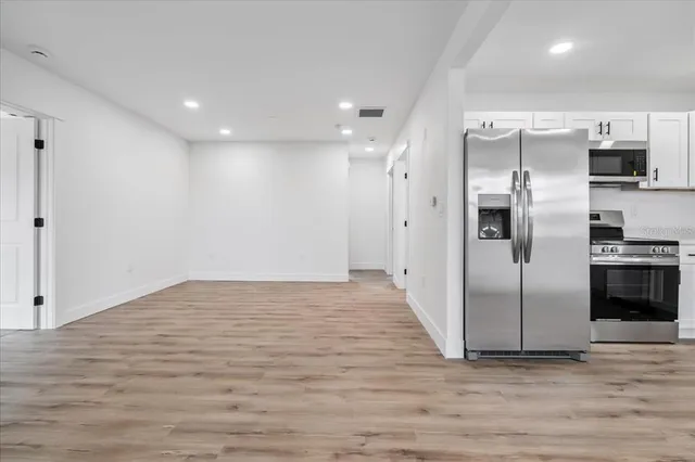 a view of a kitchen with a sink and refrigerator