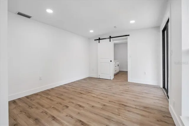a view of empty room with wooden floor and a ceiling fan