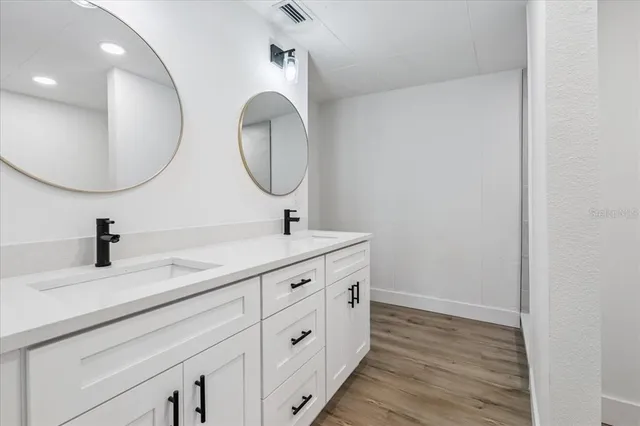 a bathroom with a double vanity sink and a mirror
