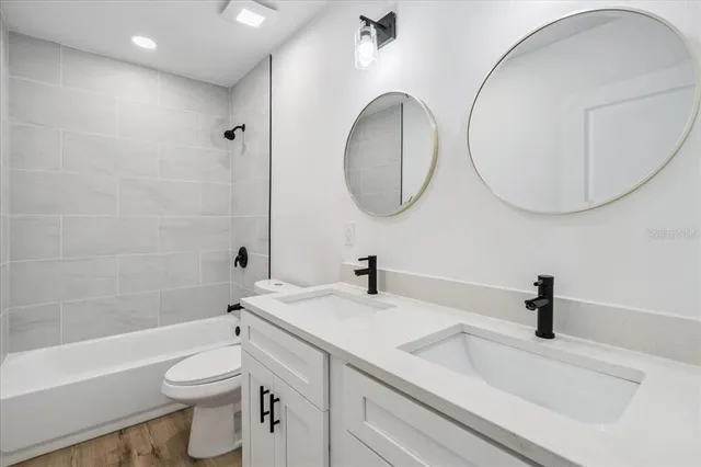 a bathroom with a sink a toilet and a mirror