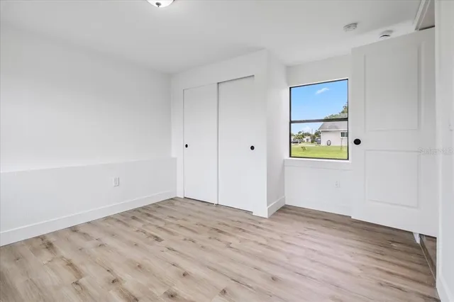 a view of empty room with wooden floor