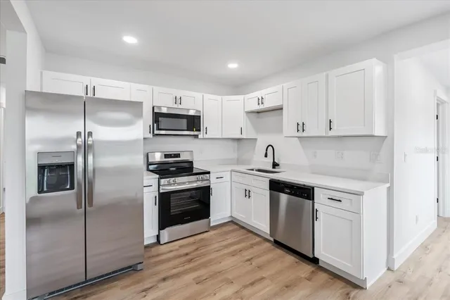 a kitchen with cabinets stainless steel appliances and a counter space