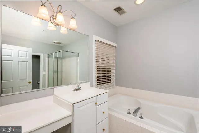 a bathroom with a sink a large mirror and a bathtub