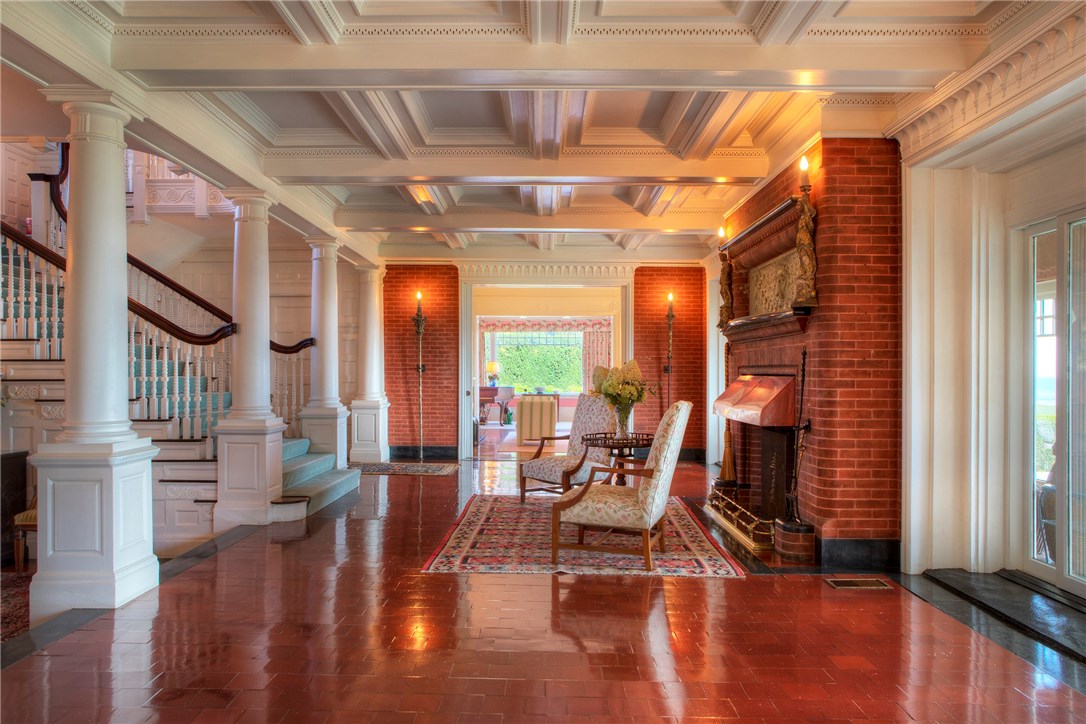 225 Ruggles Avenue Newport, RI 02840 - Photo 14 of 40 Main foyer area showing brick fireplace, coiffured ceiling, grand staircase. Living parlor in the distance.
