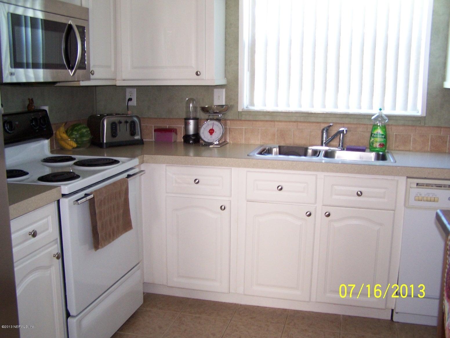 54210 Hurst Road Callahan, FL 32011 - Photo 6 of 12 a kitchen with white cabinets and white appliances