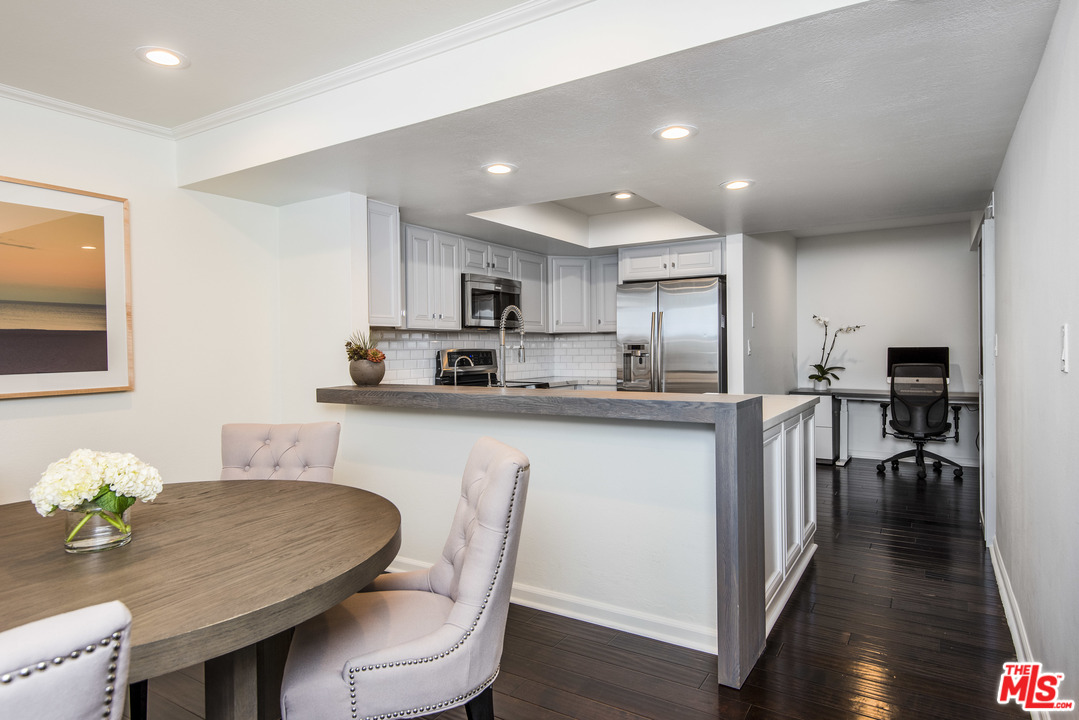 4200 Vía Dolce, Unit 129 Marina del Rey, CA 90292 - Photo 3 of 30 a kitchen with microwave a refrigerator and chairs