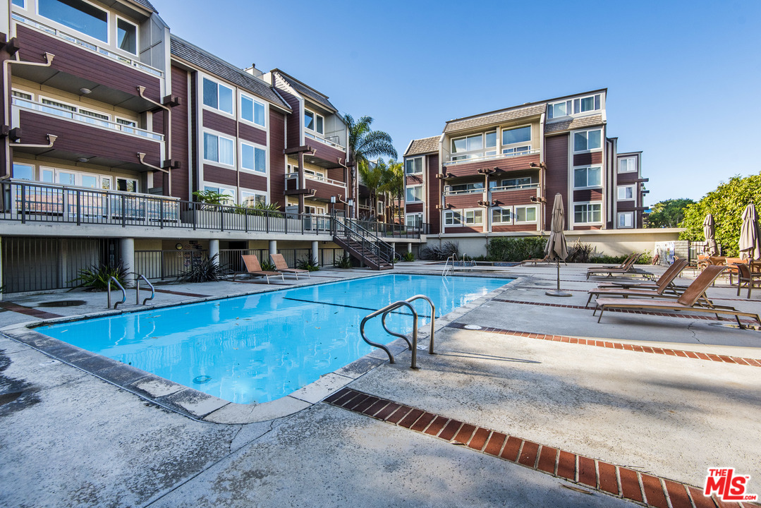 4200 Vía Dolce, Unit 129 Marina del Rey, CA 90292 - Photo 24 of 30 a view of a swimming pool with a lounge chairs