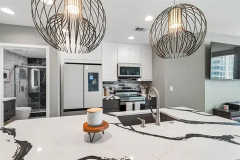 a kitchen with stainless steel appliances a stove a microwave and a hard wood floor