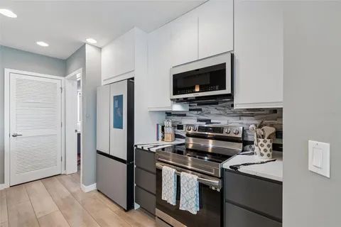 a living room with furniture a flat screen tv and kitchen view