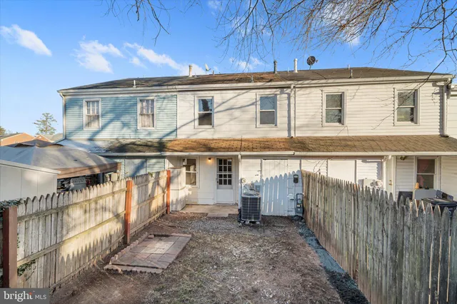 a view of a house with a floor to ceiling window and wooden fence