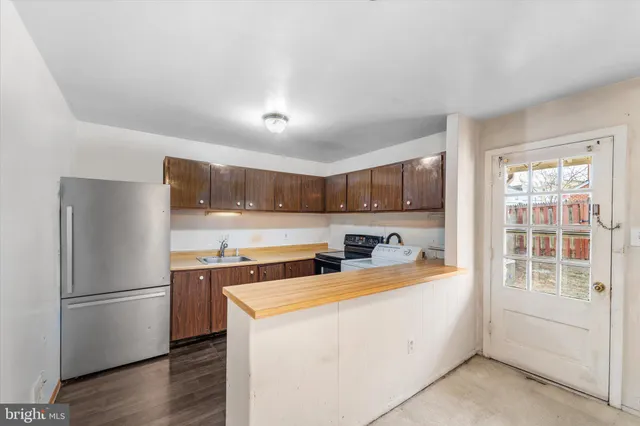 a kitchen with stainless steel appliances granite countertop a sink and a refrigerator