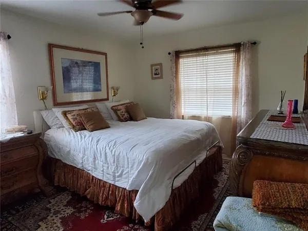 a bedroom with a bed and a dresser next to a window