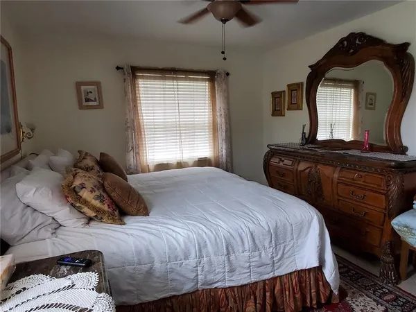 a bedroom with a bed window and dresser