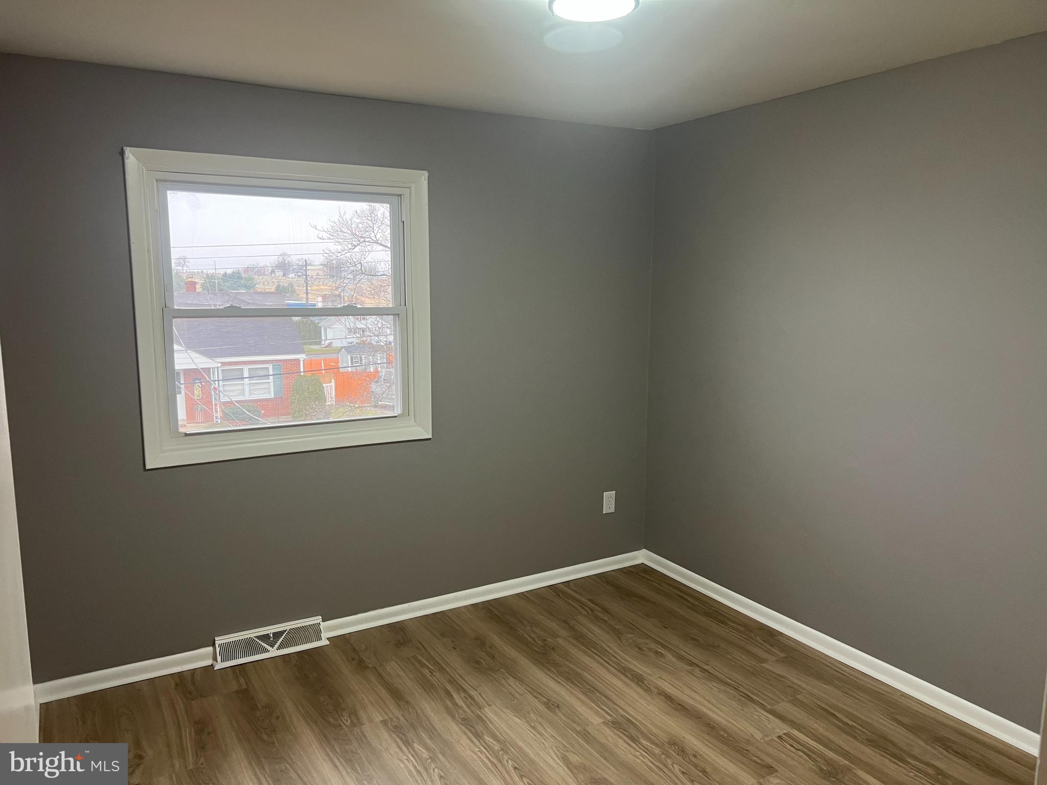 3015 Marion Street Reading, PA 19605 - Photo 11 of 11 a view of an empty room with wooden floor and a window