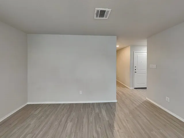 a large white kitchen with wooden floors and white walls