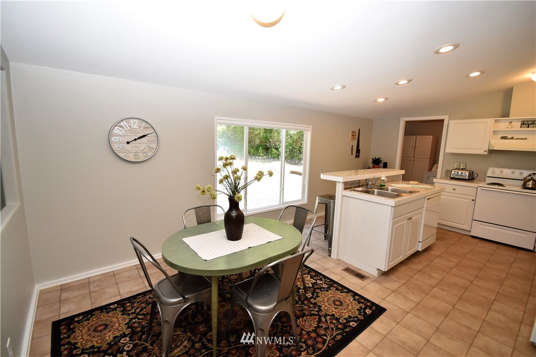 267 East Victor Road Belfair, WA 98528 - Photo 11 of 27 a kitchen with a table chairs and white cabinets