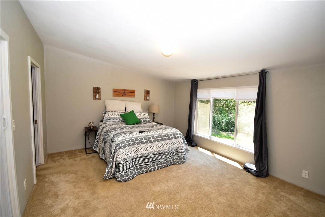 267 East Victor Road Belfair, WA 98528 - Photo 17 of 27 a spacious bedroom with a bed and a window