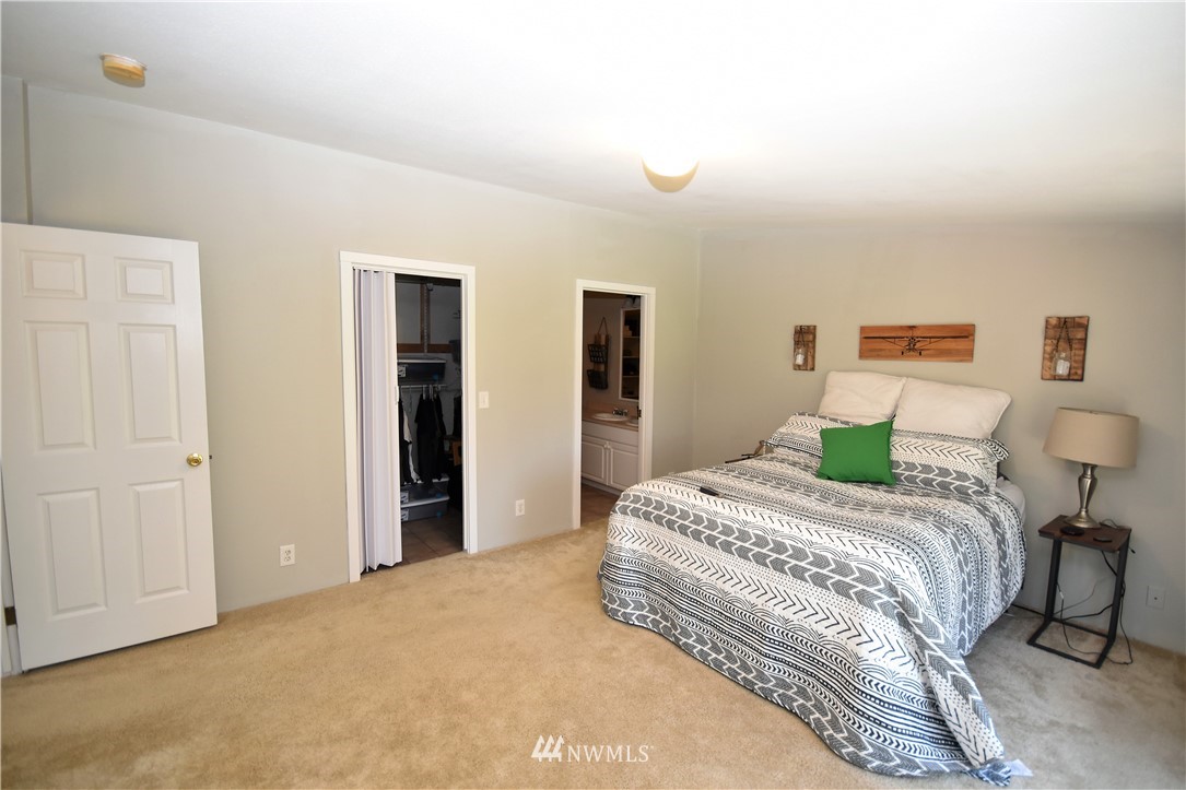 267 East Victor Road Belfair, WA 98528 - Photo 18 of 27 a bedroom with a bed and a lamp