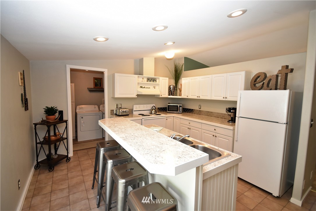 267 East Victor Road Belfair, WA 98528 - Photo 9 of 27 a kitchen with a sink a refrigerator and a stove top oven