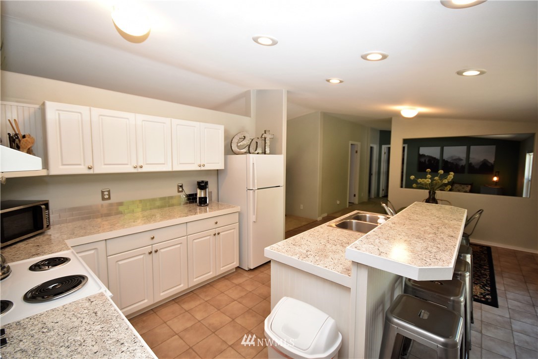 267 East Victor Road Belfair, WA 98528 - Photo 10 of 27 a kitchen with a table chairs sink and cabinets