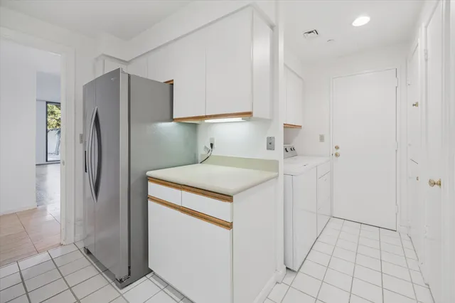 a utility room with cabinets washer and dryer