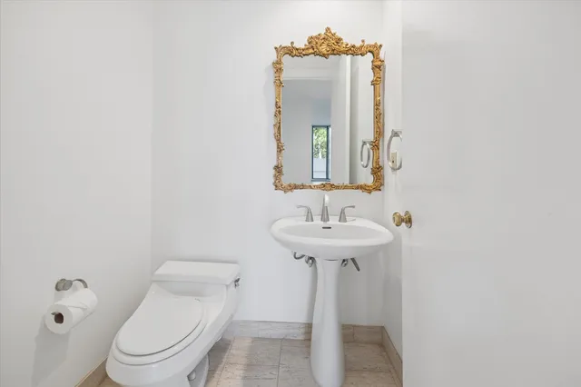 a bathroom with a toilet sink and mirror