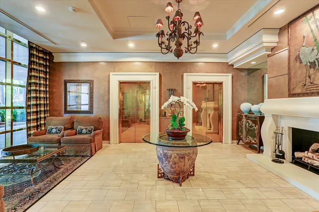 a lobby with a chandelier furniture and a potted plant
