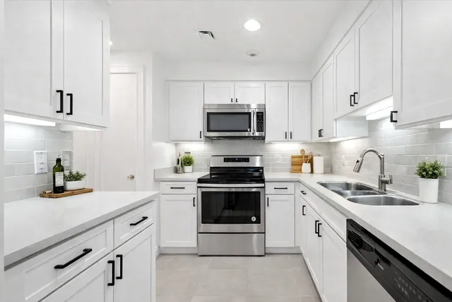 a kitchen with granite countertop a stove sink and cabinets