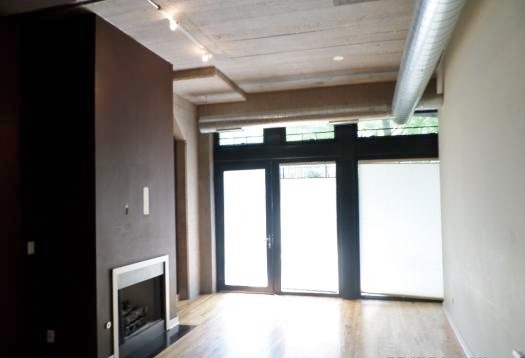 1151 West 15th Street, Unit 104 Chicago, IL 60608 - Photo 2 of 9 a view of empty room with wooden floor and fan