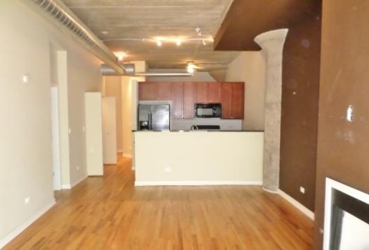 1151 West 15th Street, Unit 104 Chicago, IL 60608 - Photo 3 of 9 a view of a kitchen with a sink and a refrigerator