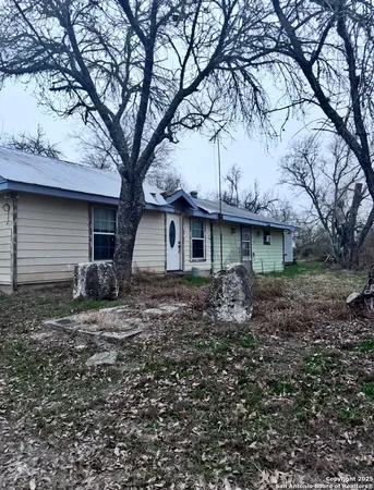 a view of a house with a yard and large tree
