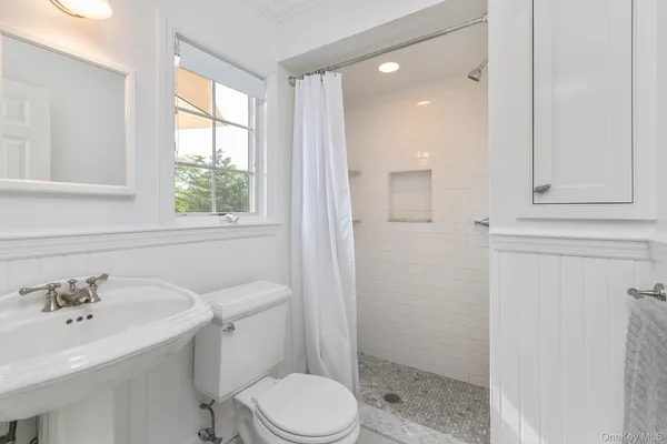 a bathroom with a sink a toilet and shower