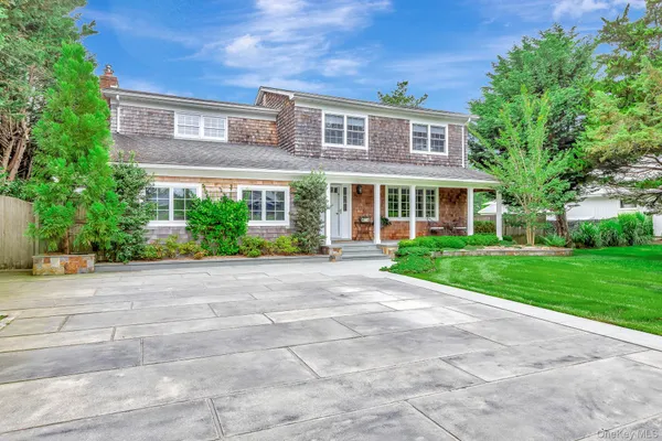 a front view of a house with a yard and potted plants