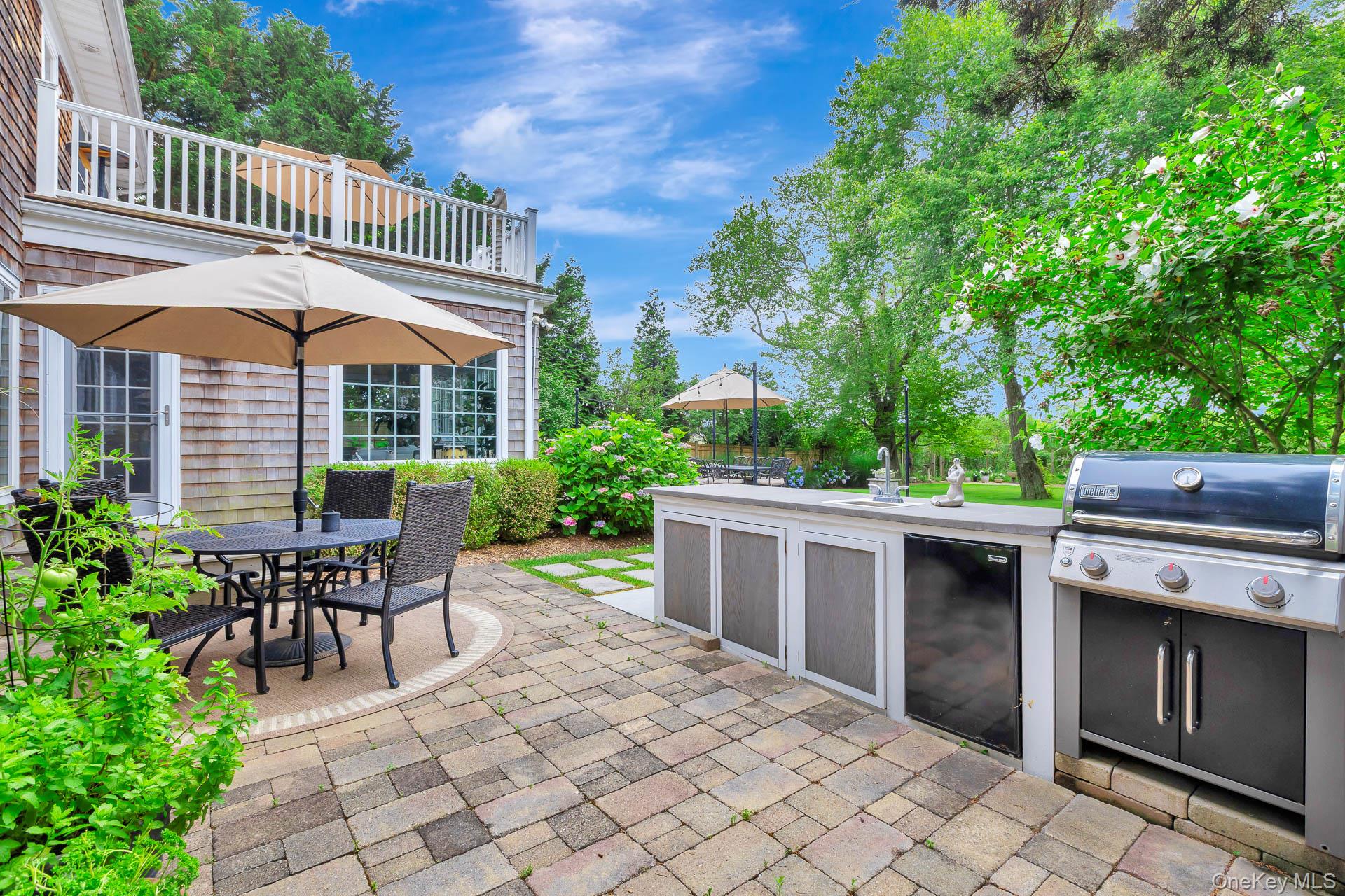51 Halsey Road Remsenburg, NY 11960 - Photo 38 of 42 a view of a patio with table and chairs potted plants and large tree