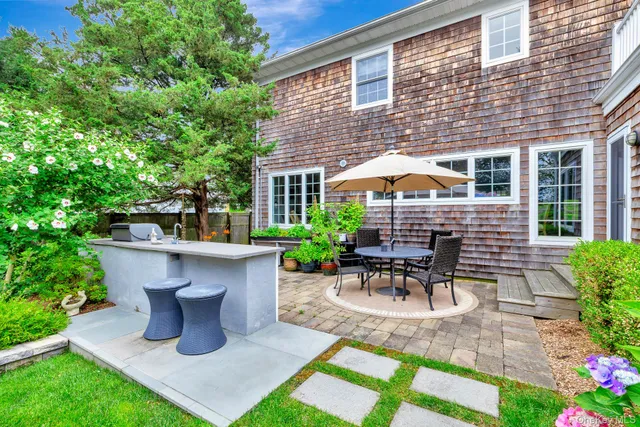 a view of a patio with table and chairs potted plants with wooden fence