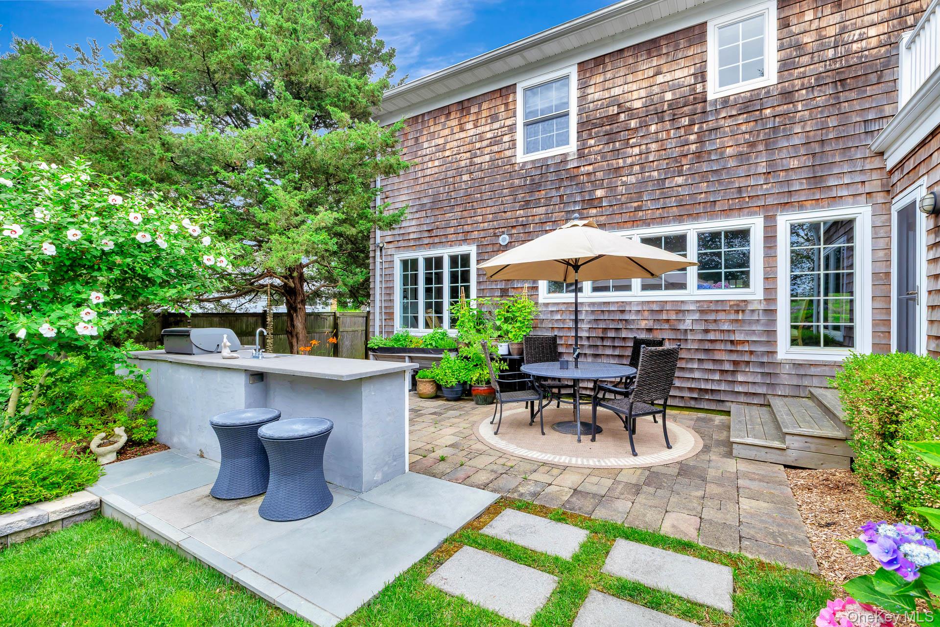 51 Halsey Road Remsenburg, NY 11960 - Photo 5 of 42 a view of a patio with table and chairs potted plants with wooden fence