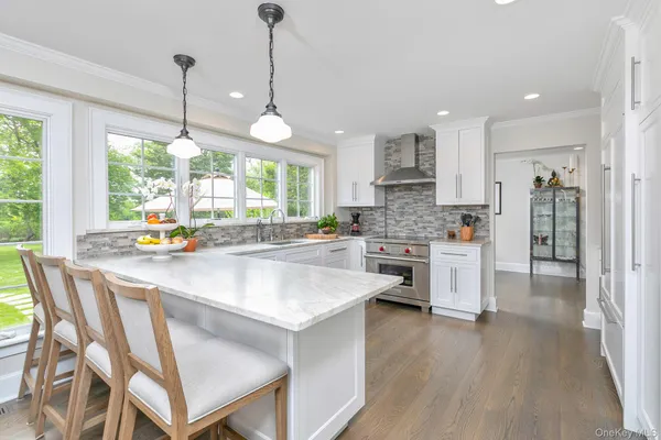 a kitchen with stainless steel appliances granite countertop a stove a refrigerator a oven a sink with a dining table and chairs