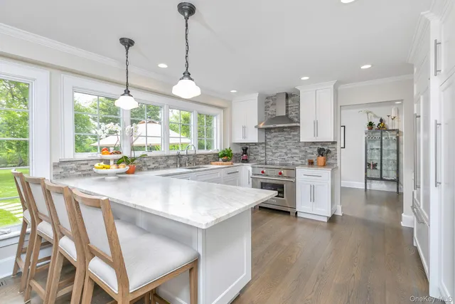 a kitchen with stainless steel appliances granite countertop a stove a refrigerator a oven a sink with a dining table and chairs