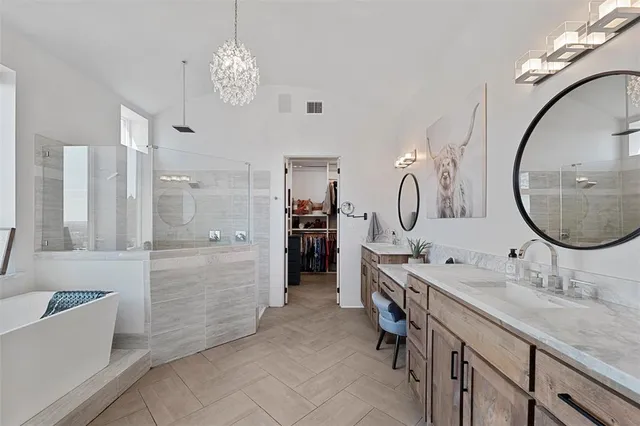 a bathroom with a granite countertop sink mirror and a bathtub