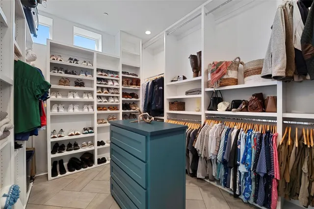 a view of walk in closet with clothes and shoes