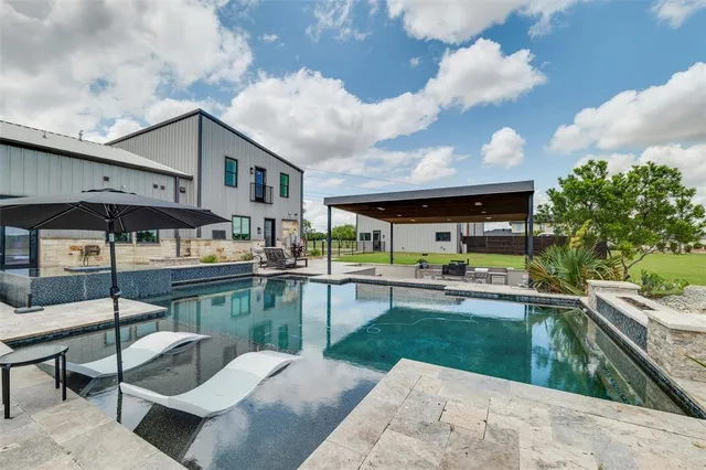 a swimming pool with outdoor seating and yard