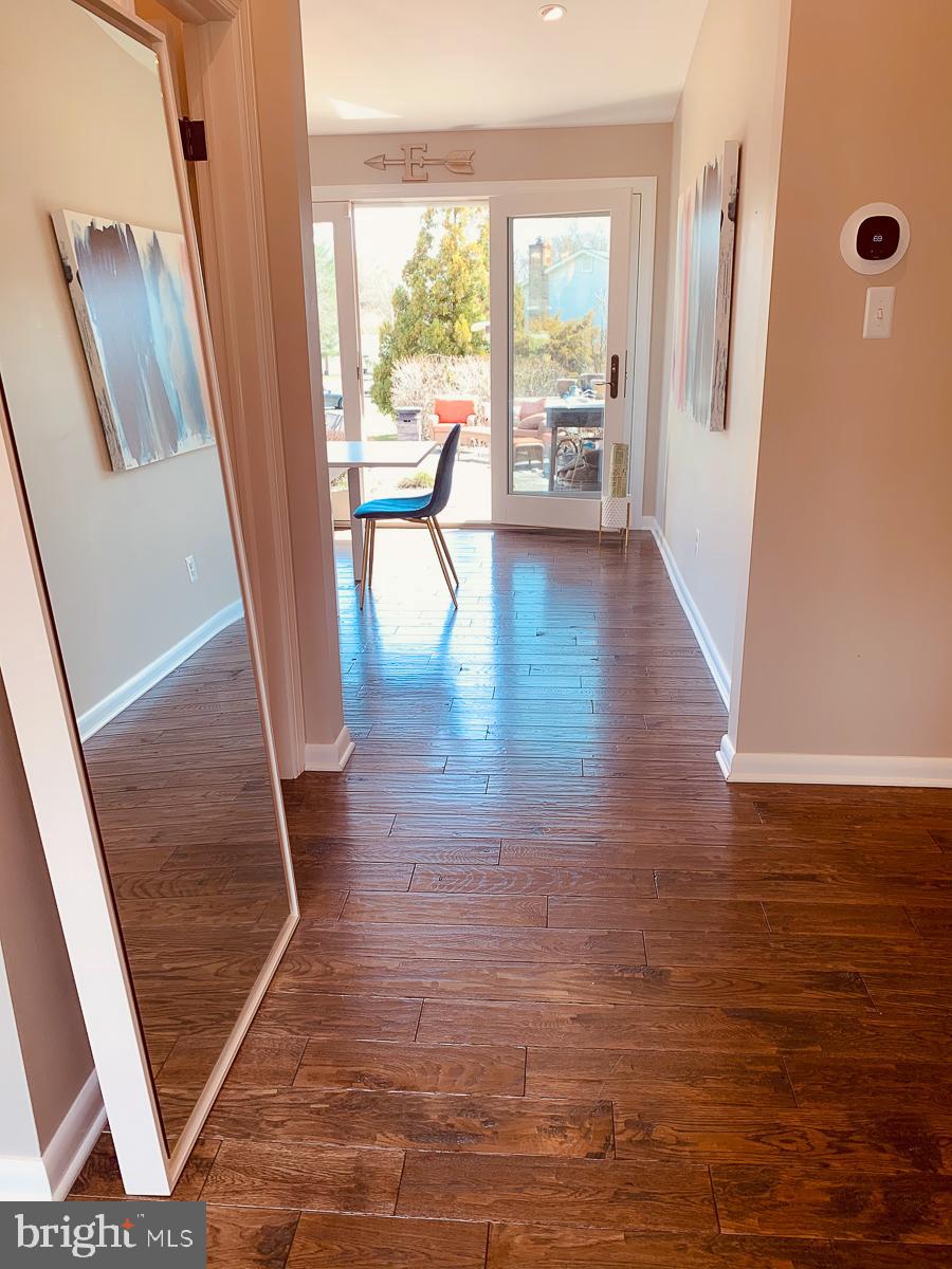 3301 Garrison Farms Road Pikesville, MD 21208 - Photo 3 of 41 Bright hallway leading to serene outdoor views.