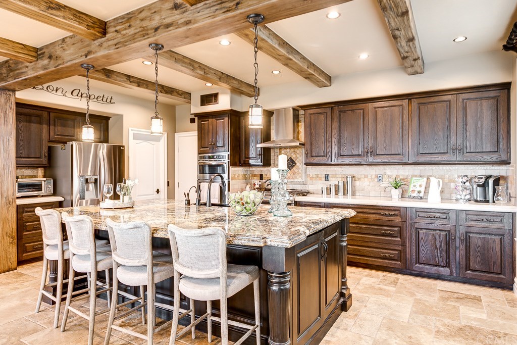 Absolutely stunning exposed Faux hand-scraped Cedar Wood Beams and Rich wood cabinetry welcome you into your exquisitely upgraded Kitchen.