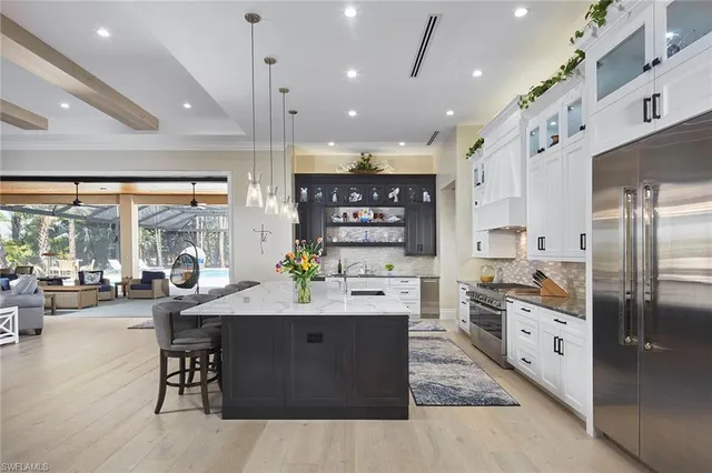 a kitchen with stainless steel appliances kitchen island granite countertop a lot of cabinets and refrigerator