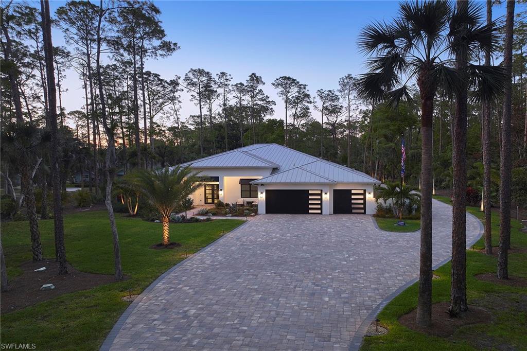 5301 Tamarind Ridge Drive Naples, FL 34119 - Photo 3 of 50 a front view of a house with garden