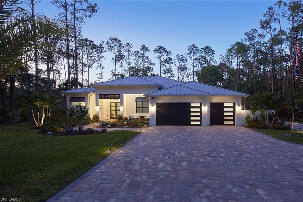 5301 Tamarind Ridge Drive Naples, FL 34119 - Photo 4 of 50 a front view of a house with a garden and trees