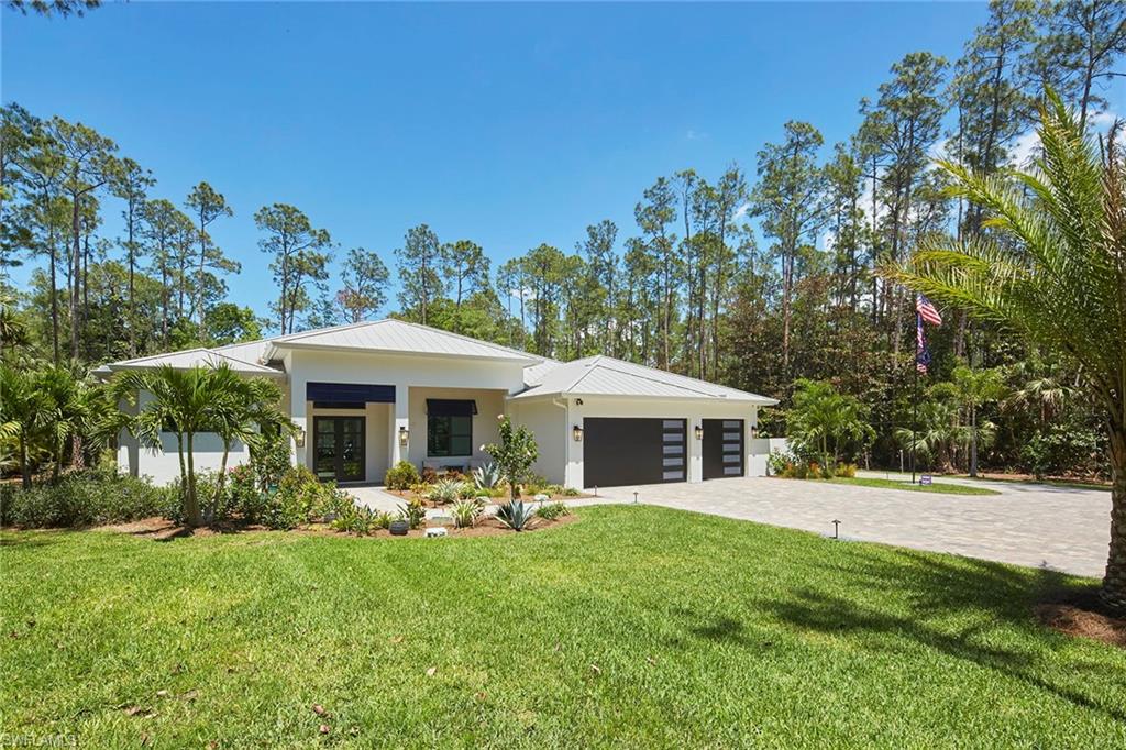 5301 Tamarind Ridge Drive Naples, FL 34119 - Photo 45 of 50 a front view of a house with a yard table and chairs