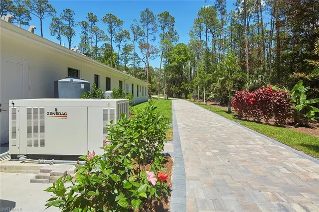 a front view of a house with a yard and trees