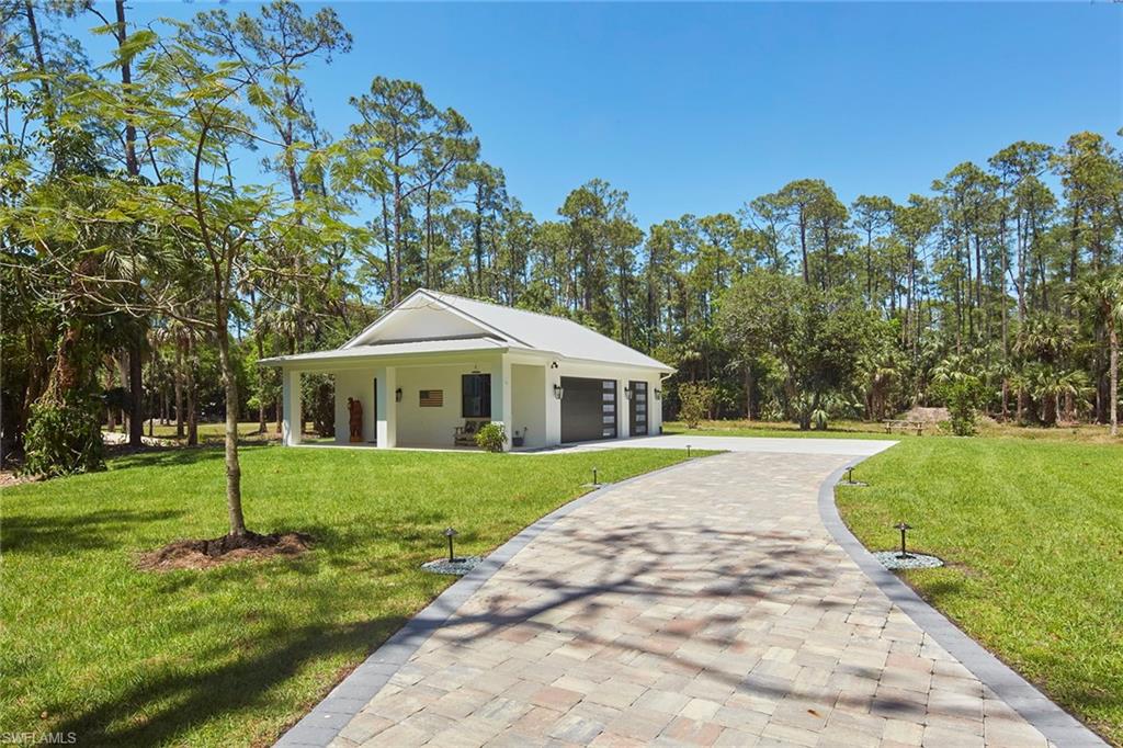 5301 Tamarind Ridge Drive Naples, FL 34119 - Photo 48 of 50 a front view of a house with a yard and trees