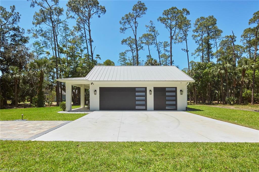 5301 Tamarind Ridge Drive Naples, FL 34119 - Photo 49 of 50 a front view of a house with a yard and trees